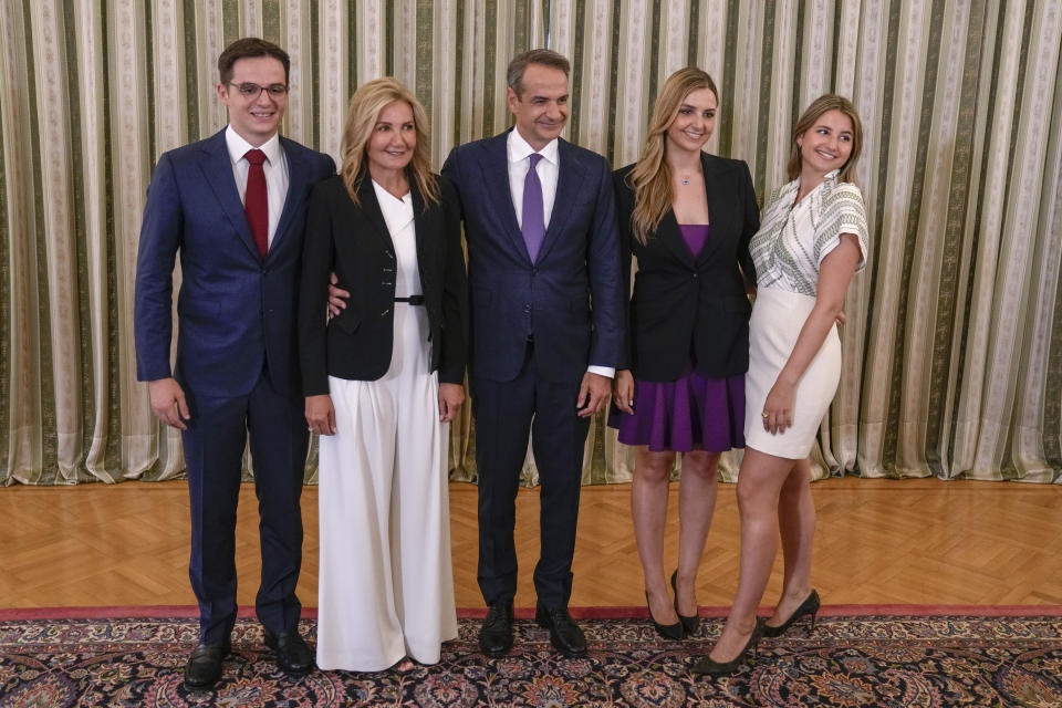 Greece's Prime Minister Kyriakos Mitsotakis, center, poses for the media with his wife Mareva Grabowski-Mitsotakis, second left, and their children Konstantinos, left, Dafni, second right, and Sofia, after taking the oath at the Presidential Palace, in Athens, Greece, Monday, June 26, 2023. Greece's center-right leader Kyriakos Mitsotakis was formally sworn in as prime minister Monday after easily winning a second term with a record-high margin over the left-wing opposition, in an election that also ushered new far-right parties into Parliament. (AP Photo/Thanassis Stavrakis)
