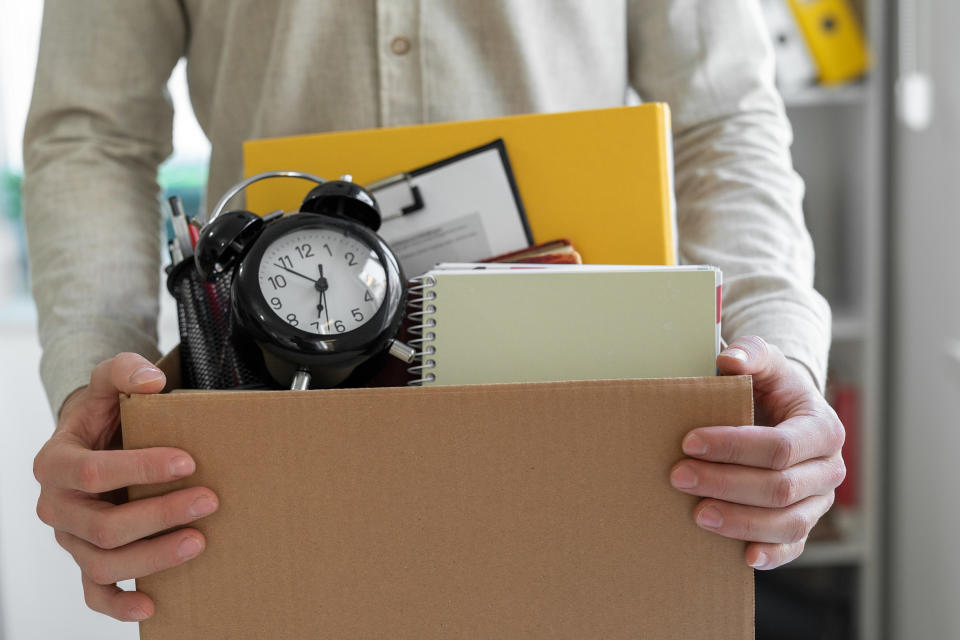 man walking out of an office with a box of his stuff