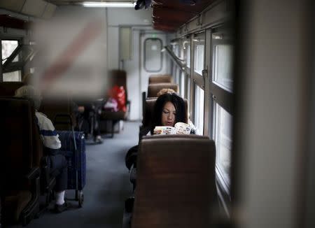 A passenger reads a book as she travels on a train to Velingrad railway station, Bulgaria April 28, 2015. REUTERS/Stoyan Nenov