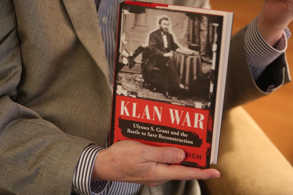 Civil Rights Attorney Tom Neuberger holds a copy of the book 'Klan War' to illustrate the threat that white supremacy poses to the Black community. He recently filed a lawsuit against a new state law requiring people to have a permit before purchasing a handgun.