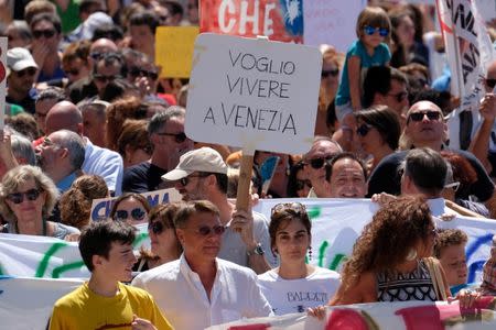 A resident holds a placard " I want to live in Venice" during a protest in Venice, Italy, July 2, 2017. Picture taken on July 2, 2017REUTERS/Manuel Silvestri