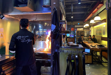 An employee roasts pork at a Korean BBQ restaurant in Seoul, South Korea, March 13, 2019. REUTERS/Jane Chung