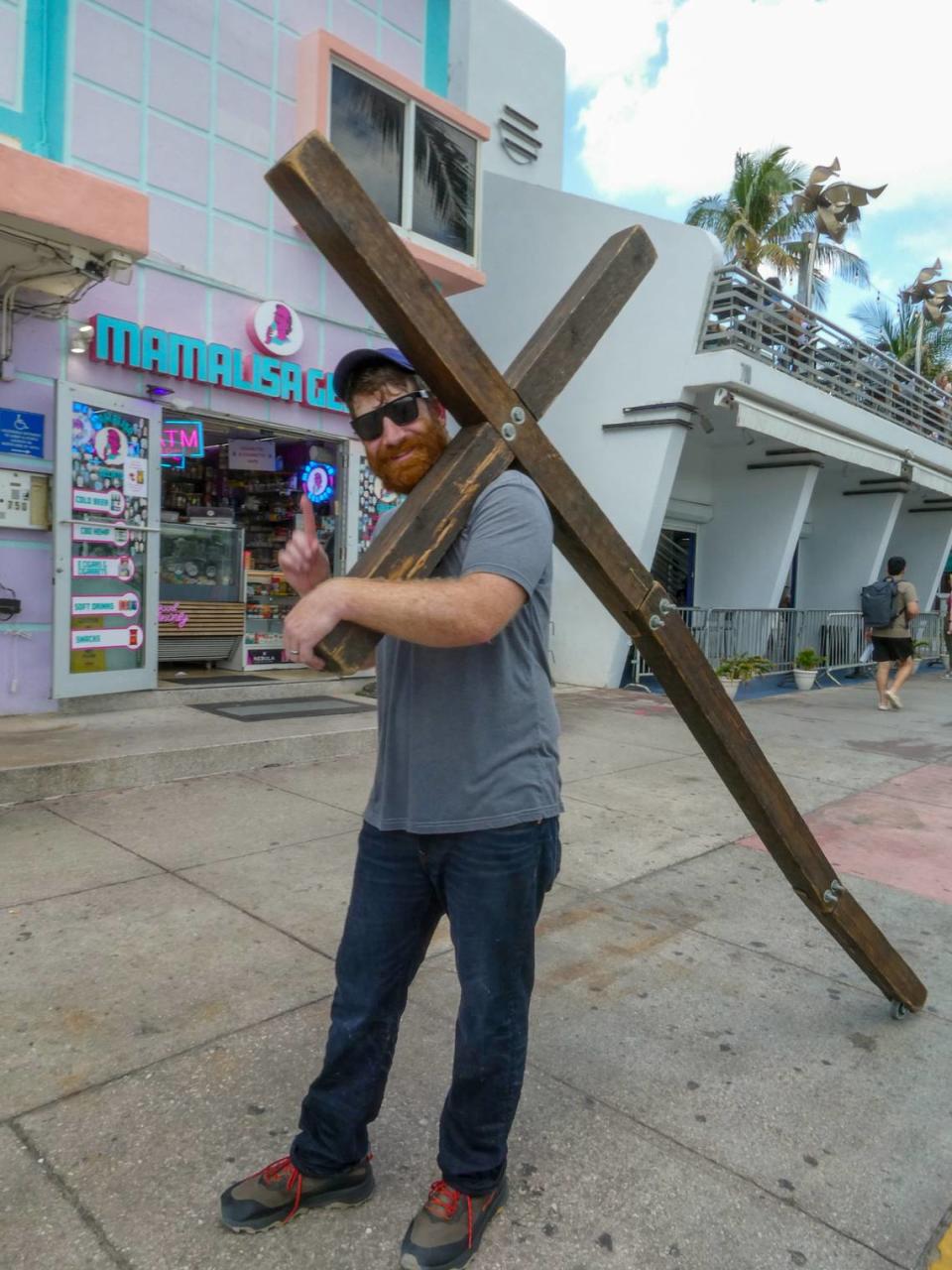 Wade Aaron, de 35 años, caminaba por Ocean Drive con una gran cruz de madera al hombro mientras visitaba Miami Beach durante las vacaciones de primavera, el domingo 10 de marzo de 2024.