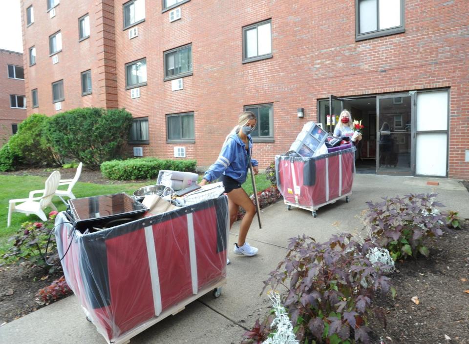 Sarah Moschini, of Upton, left, and Jakki Cloutier, of Northbridge, move their belongings into the Eastern Nazarene College dorm on Saturday, Aug. 22, 2020.