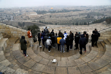 FILE PHOTO: A group of tourists listens to a tour guide on a foggy day, in an observation point on Mount of Olives overlooking Jerusalem's Old City, January 2, 2018. REUTERS/Ammar Awad/File Photo