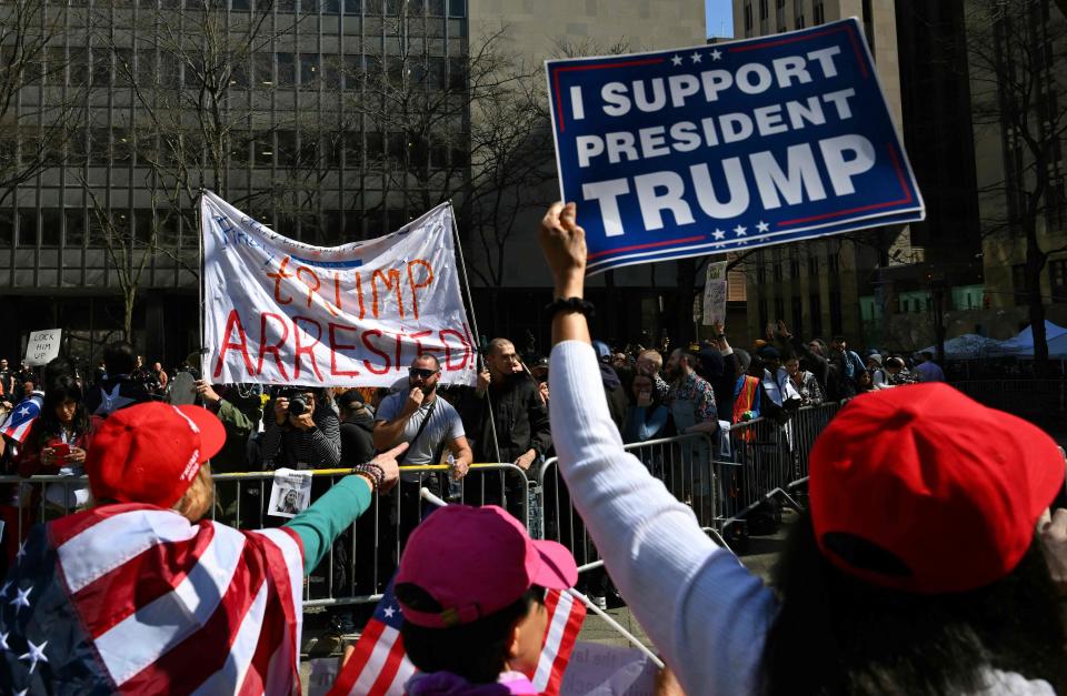 Supporters of former president Donald Trump argue with opponents outside the Manhattan District Attorney's office.