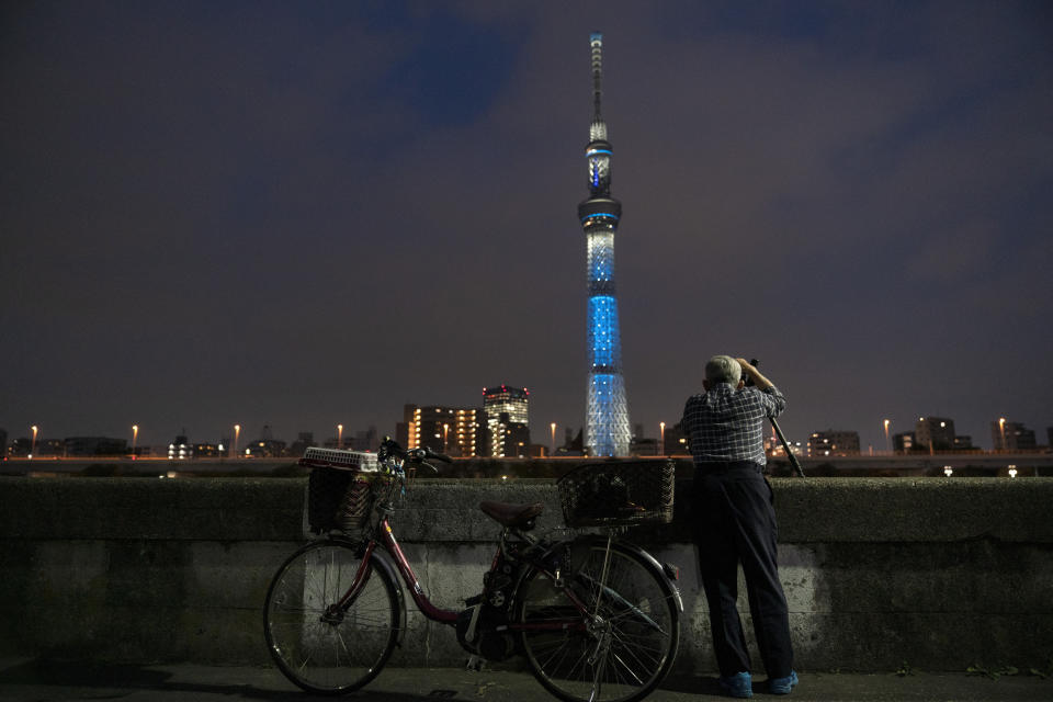 Kiyoshi Ozawa, 77, takes pictures of the Skytree, the world's tallest tower in Tokyo, June 20, 2019. (AP Photo/Jae C. Hong)