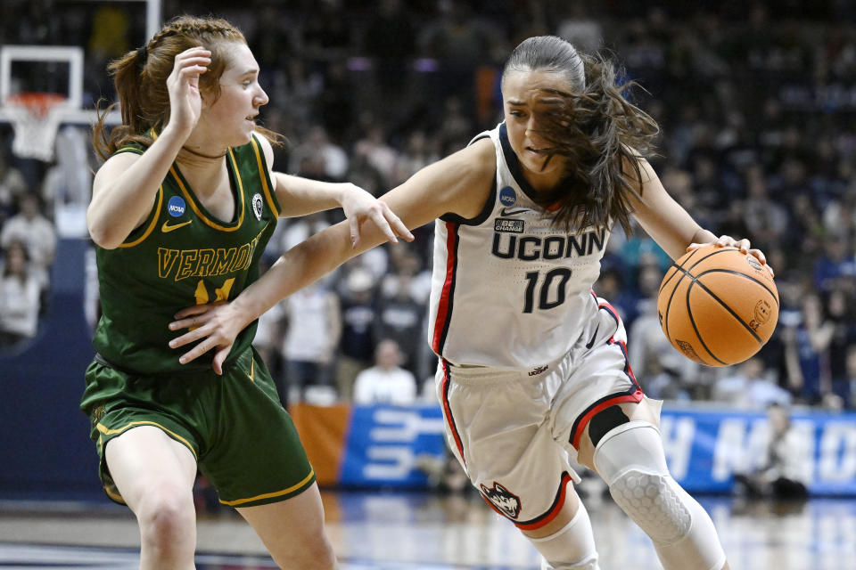 UConn's Nika Muhl (10) drives as Vermont's Catherine Gilwee (14) defends in the second half of a first-round college basketball game in the NCAA Tournament, Saturday, March 18, 2023, in Storrs, Conn. (AP Photo/Jessica Hill)