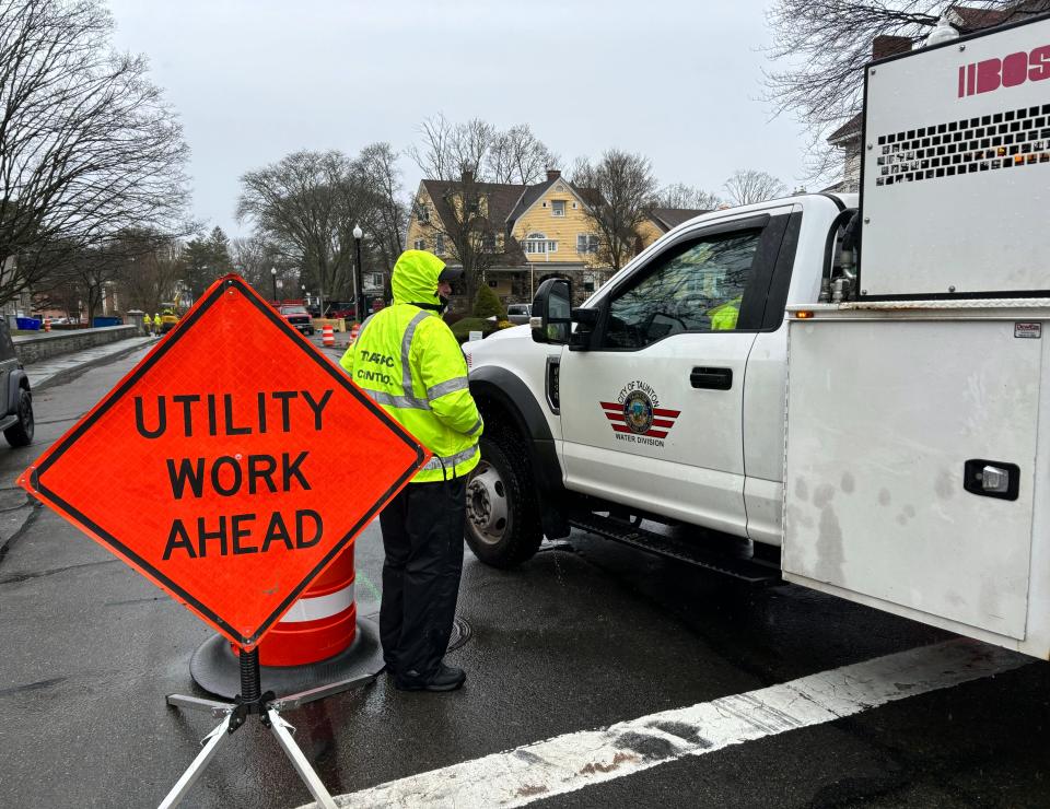 A civilian traffic control officer is seen here on April 4 at Church Green conferring with an employee from Taunton's DPW water division.