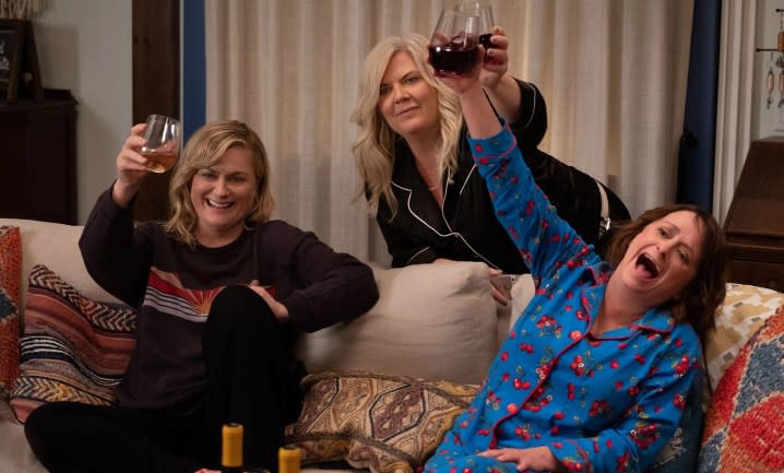 Three women raise their wine glasses in Wine Country.