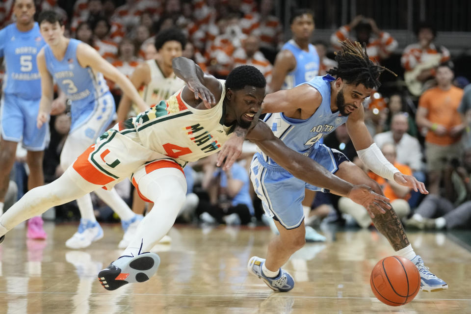 North Carolina guard RJ Davis, right, and Miami guard Bensley Joseph battle for a ball during the second half of an NCAA college basketball game, Saturday, Feb. 10, 2024, in Coral Gables, Fla. (AP Photo/Rebecca Blackwell)