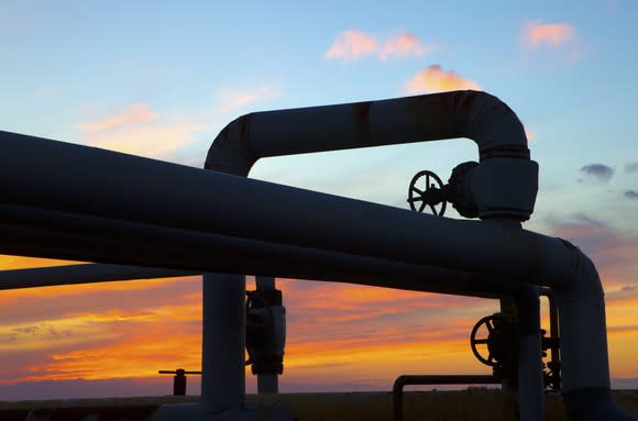 Sunset through the twists of a pipeline system.