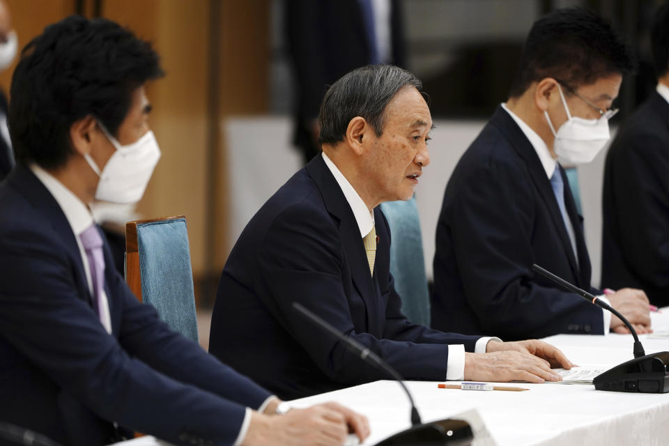 Japanese Prime Minister Yoshihide Suga, center, declares a state of emergency for Tokyo and three other prefectures during the government task force meeting for the COVID-19 measures at the prime minister's office Friday, April 23, 2021, in Tokyo. (AP Photo/Eugene Hoshiko, Pool)