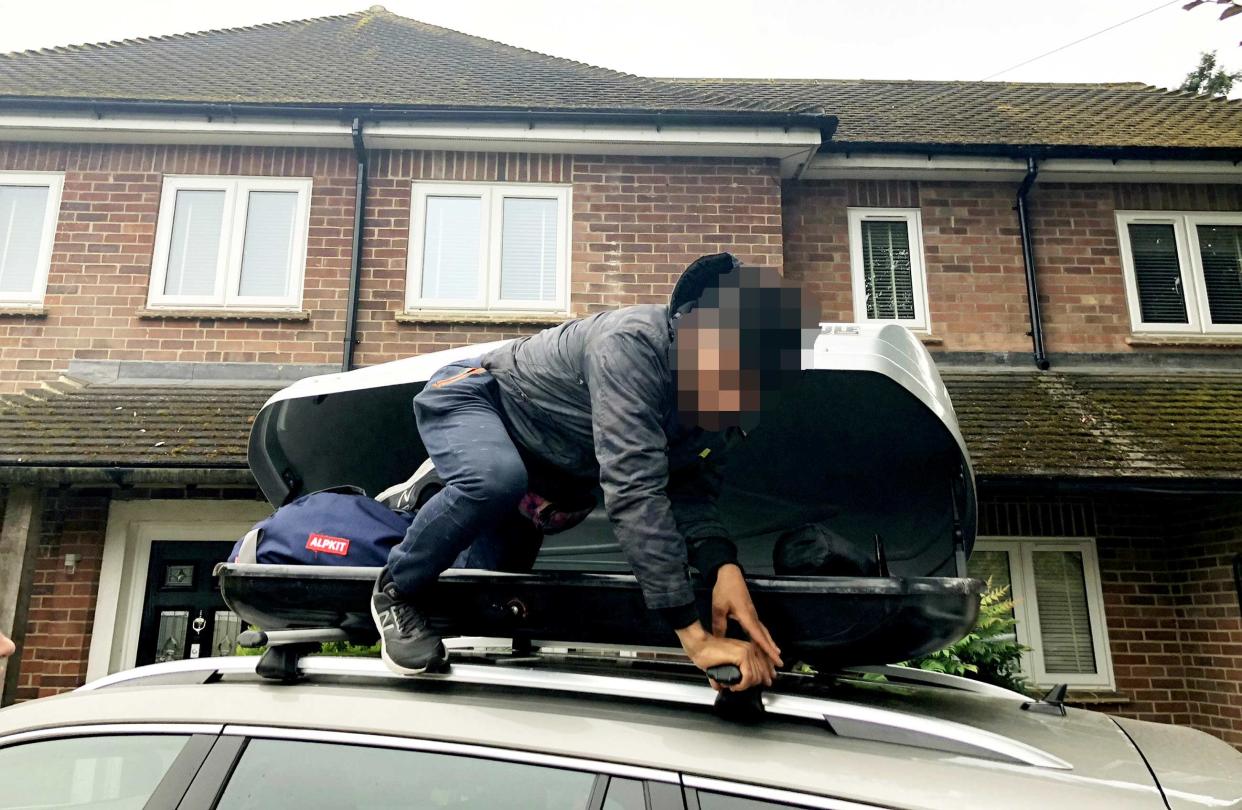 The young stowaway pictured clambering out of Simon Fenton's family car's roof box in Newbury, Berkshire. (SWNS)