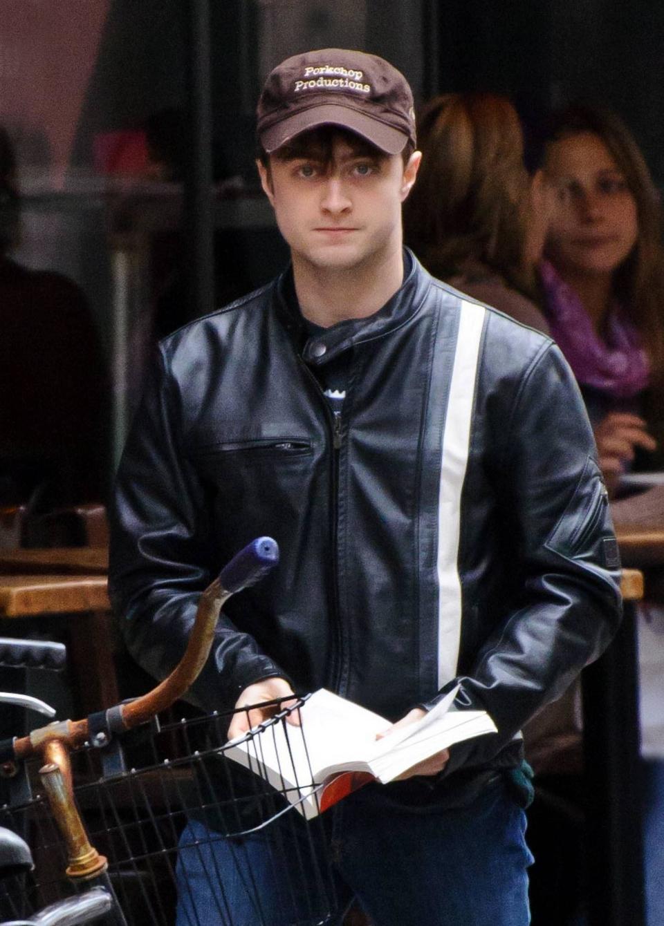 Daniel Radcliffe reading a book and walking