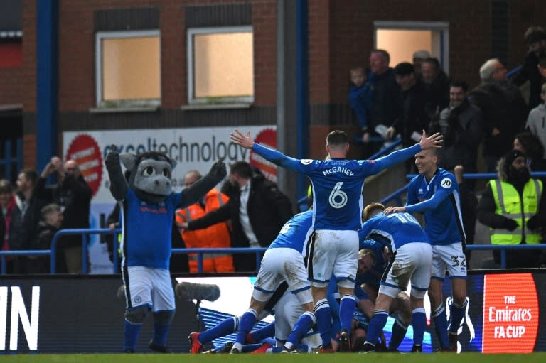 Rochdale's players, and their mascot, celebrated after Ian Henderson scores the opening goal