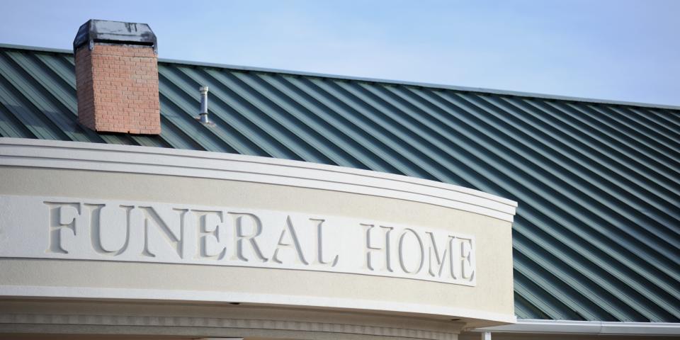 A sign says "funeral home" on a building.