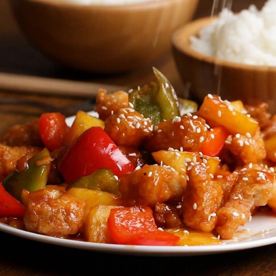 Plate of fried pork with veggies and rice