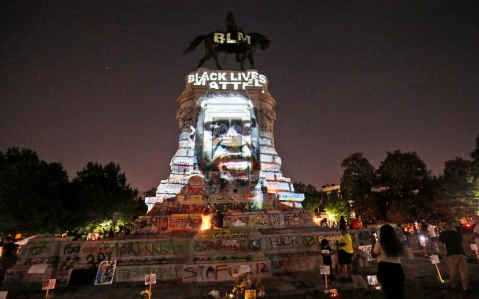 A picture of George Floyd is projected on to the Robert E. Lee statue in Richmond, along with the phrase Black Lives Matter - Steve Helber/AP