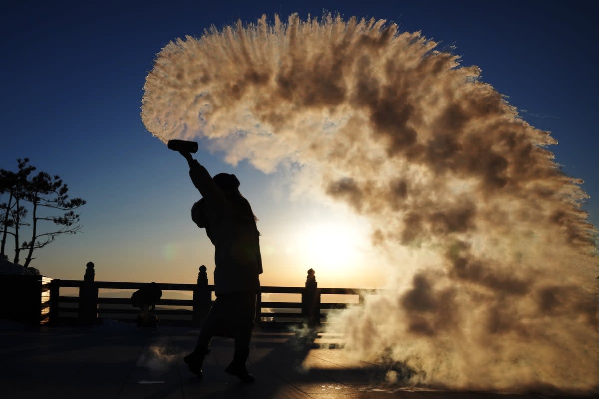 A tourist pours water in the air in Heilongjiang Province, China, (EPA)