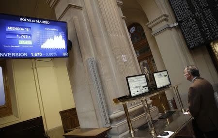 A trader looks at computer screens at Madrid's bourse November 17, 2014. REUTERS/Andrea Comas