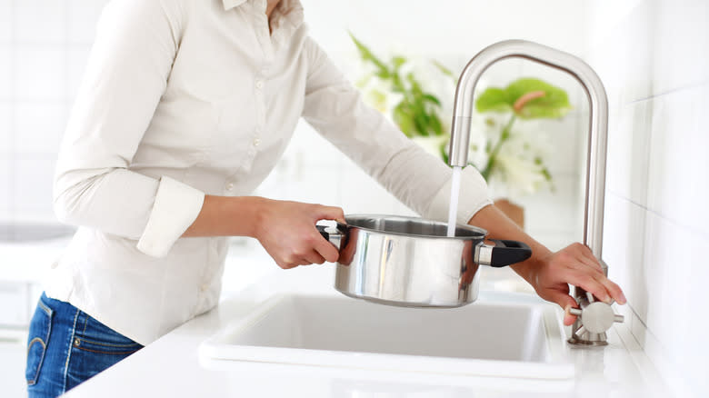 Woman filling pot with water