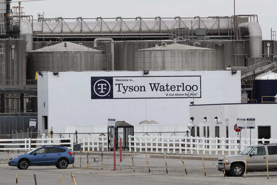 Vehicles sit in a near empty parking lot outside the Tyson Foods plant, Friday, May 1, 2020, in Waterloo, Iowa. (AP Photo/Charlie Neibergall)