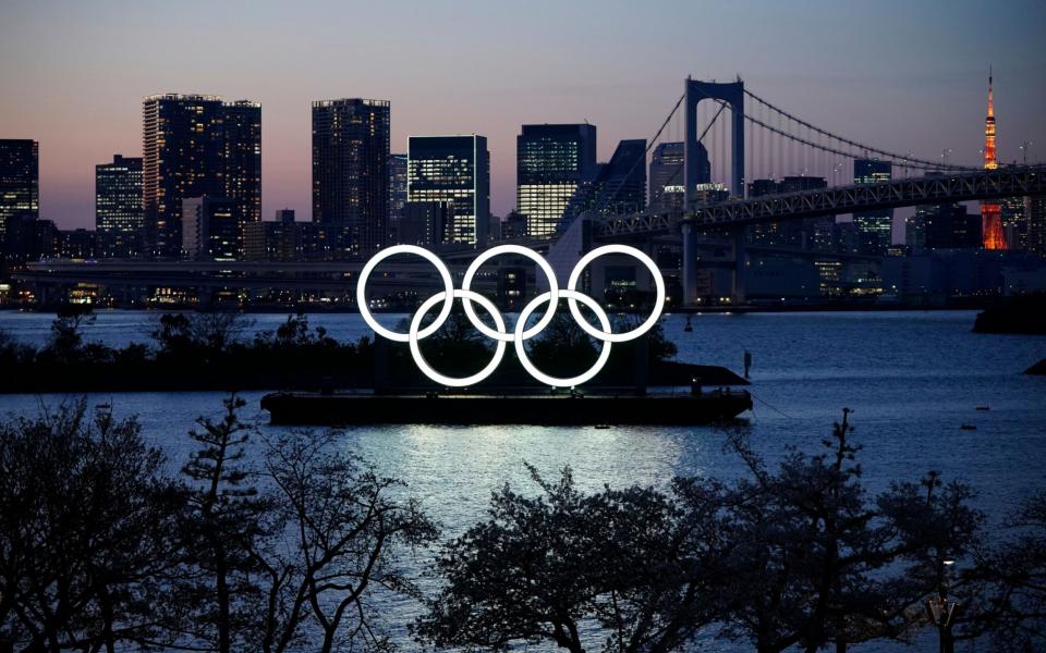 A giant Olympic rings monument is illuminated at dusk at Odaiba Marine Park in Tokyo - SHUTTERSTOCK