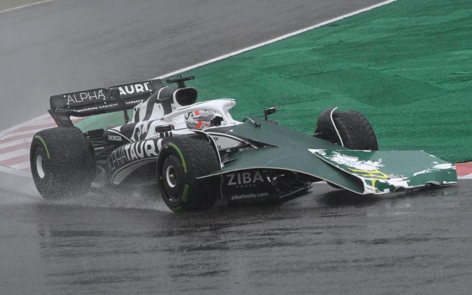 Some signage blows onto the front of the car of AlphaTauri's French driver Pierre Gasly during a rainstorm at the Formula One Japanese Grand Prix at Suzuka, Mie prefecture on October 9, 2022 - AFP