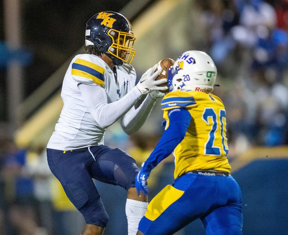 Winter Haven (8) Guiseann Mirtil pulls in a pass over Auburndale (20) Claude Feron during first-half action In Auburndale on Nov. 3, 2022.