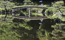 <p>A woman with a parasol crosses a bridge on the pond at Kiyosumi Gardens in Tokyo, May 19, 2017. The temperature in Tokyo soared to 26.3 degrees Celsius (79 degrees Fahrenheit). (Photo: Koji Sasahara/AP) </p>