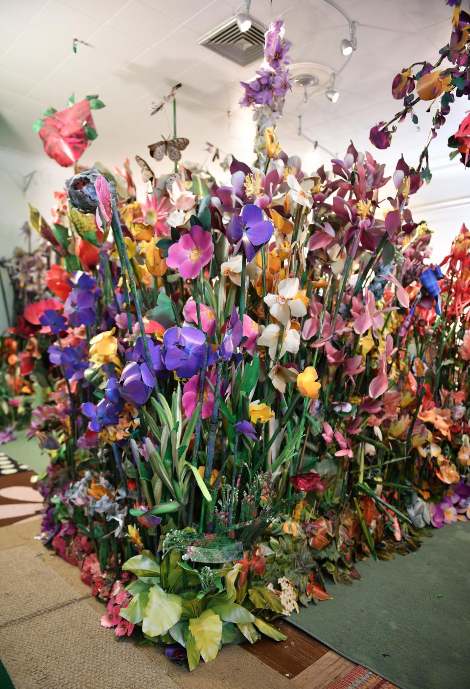 An island of paper flowers more than six feet tall in Sandy Payson's Sarasota home. Payson has created a garden of sculptural paper flowers using photos from coffee table flower books. 