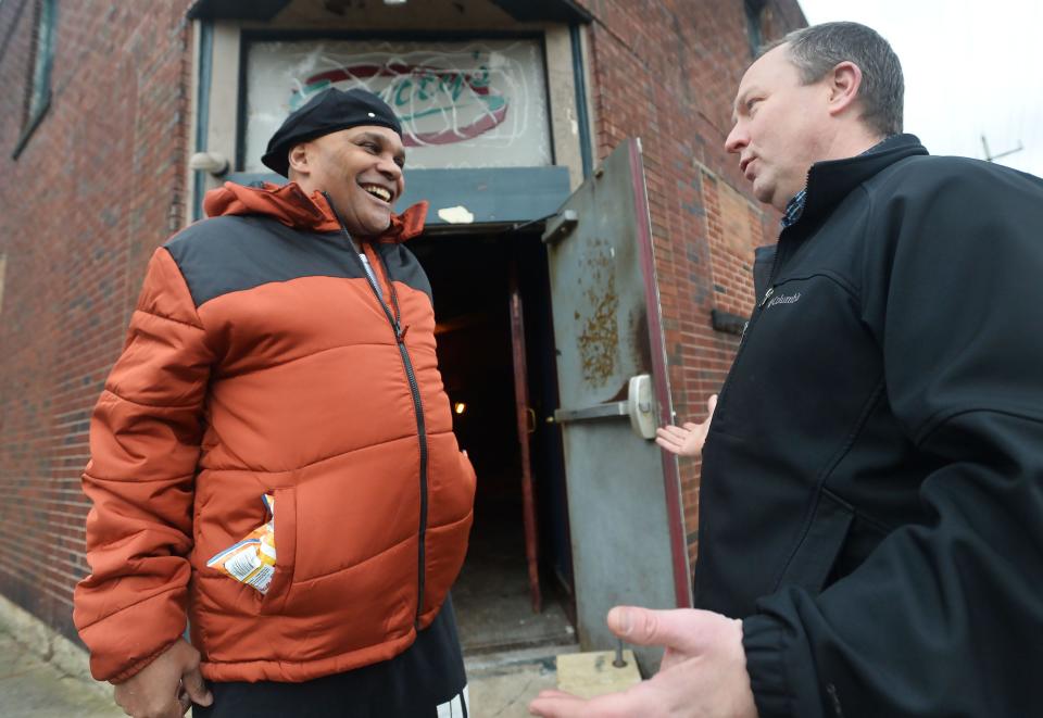 Erie resident and nearby neighbor Jeff Marsh, 60, left, talks with Jeremy Bloeser, executive director of Bayfront Eastside Task Force, outside the former Scotty’s Cigar & Martini Lounge on the southeast corner of East Third and German streets. BEST purchased the dilapidated building a few years ago and plans to demolish it and create a neighborhood park.