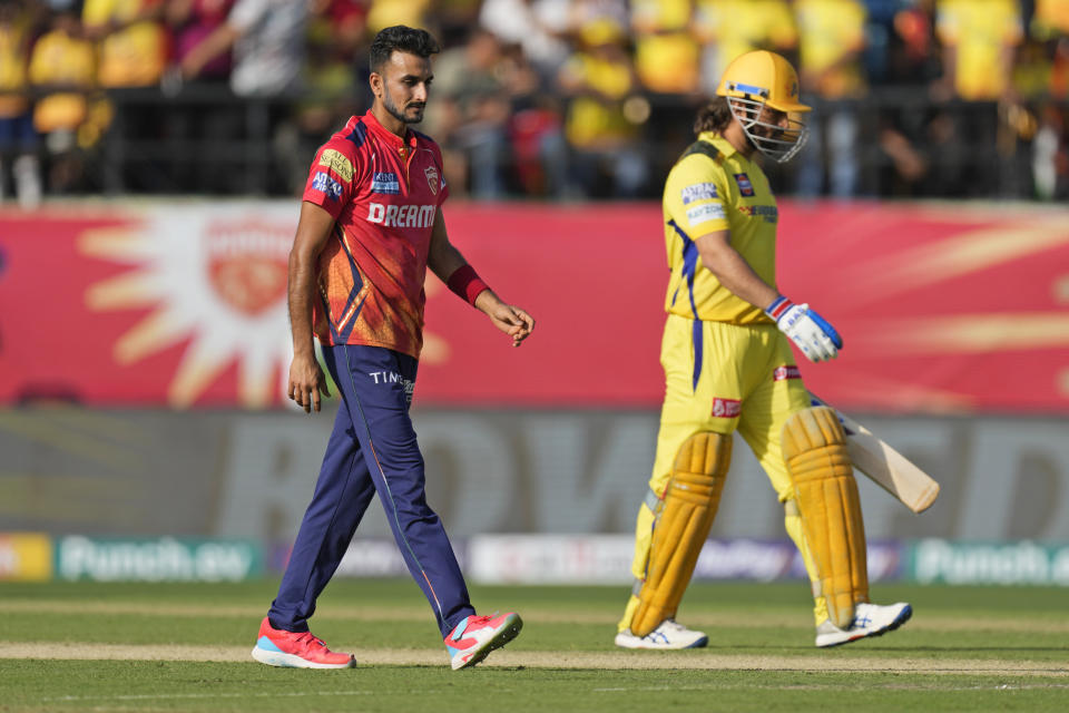 Chennai Super Kings' MS Dhoni, right, walks off the field after losing his wicket to Punjab Kings' Harshal Patel, left, during the Indian Premier League cricket match between Chennai Super Kings and Punjab Kings in Dharamshala, India, Sunday, May 5, 2024. (AP Photo /Ashwini Bhatia)