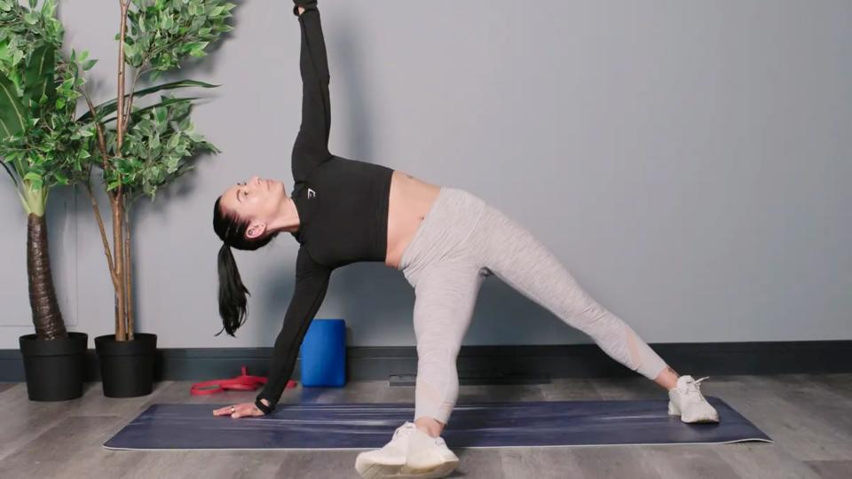 Writer Sam performing a starburst plank on yoga mat in studio