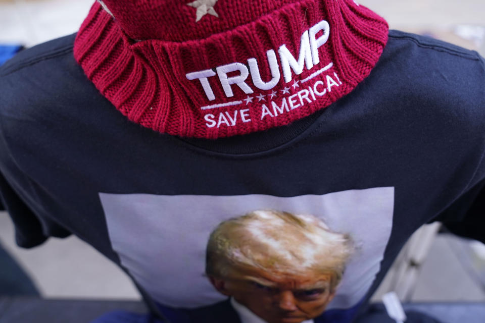 Merchandise is seen in a vendor tent outside a former President Donald Trump commit to caucus rally, Sunday, Oct. 29, 2023, in Sioux City, Iowa. (AP Photo/Charlie Neibergall)