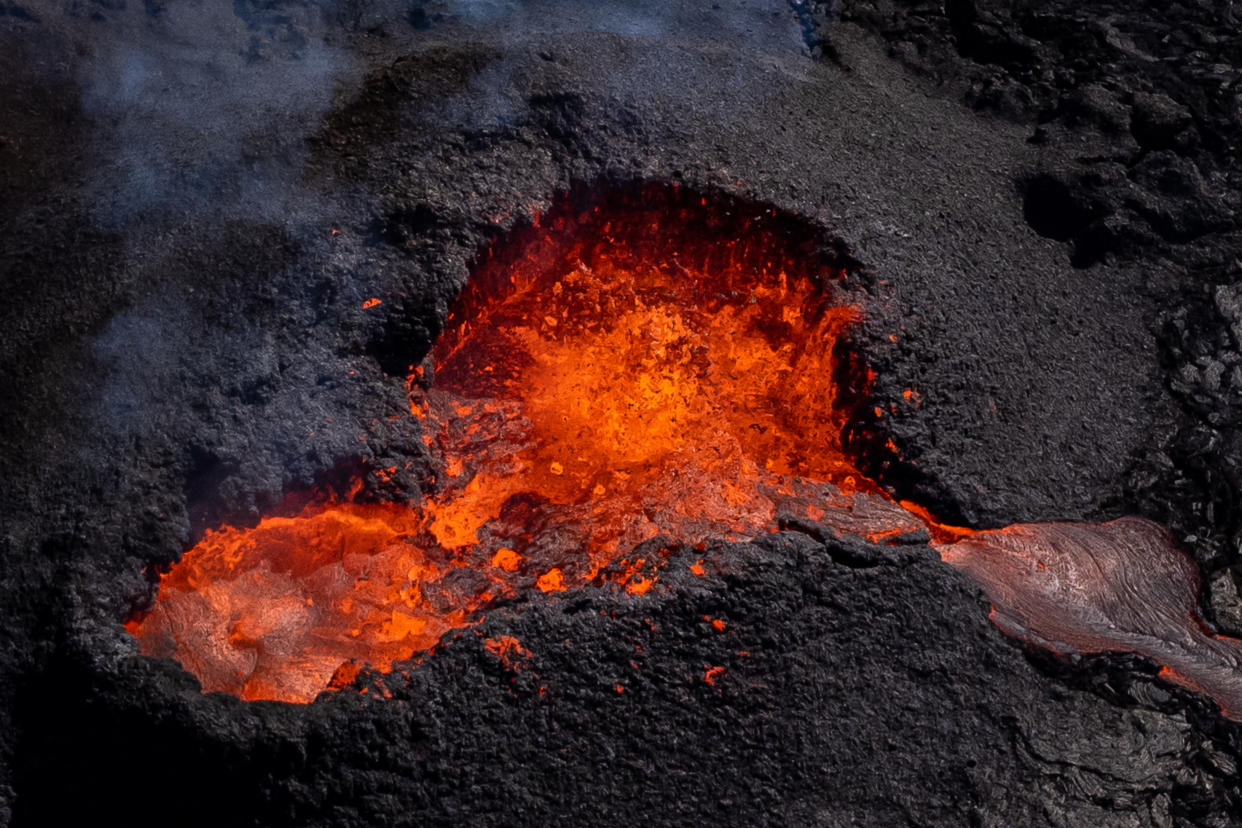 Magma flows from a heart shaped crater at the volcano in Fagradalsfjall, Iceland, following an eruption from a new fissure on the Reykjanes Peninsula, around 35 miles from the capital city of Reykjavic, the eruption has been ongoing since the 3rd August 2022. Picture date: Monday August 15, 2022. (Photo by Aaron Chown/PA Images via Getty Images)