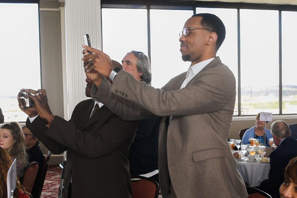 Brian "Penny" Collins takes a photo of his dad accepting his MNPS's Sports Hall of Fame award during the induction ceremony at Millennium Maxwell House in Nashville, Tenn., Thursday, April 7, 2022. 