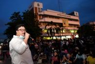 Parit Chiwarak speaks to supporters outside a police station where fellow protester Anon Nampa was arrested in Bangkok