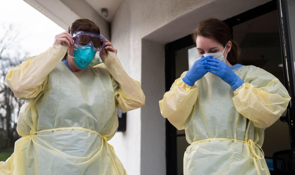 Health care workers from Virginia Hospital Center put on their personal protective equipment before people arrive at a drive through testing site for coronavirus in Arlington, Virginia. on March 20, 2020. (Photo by ANDREW CABALLERO-REYNOLDS / AFP) (Photo by ANDREW CABALLERO-REYNOLDS/AFP via Getty Images)