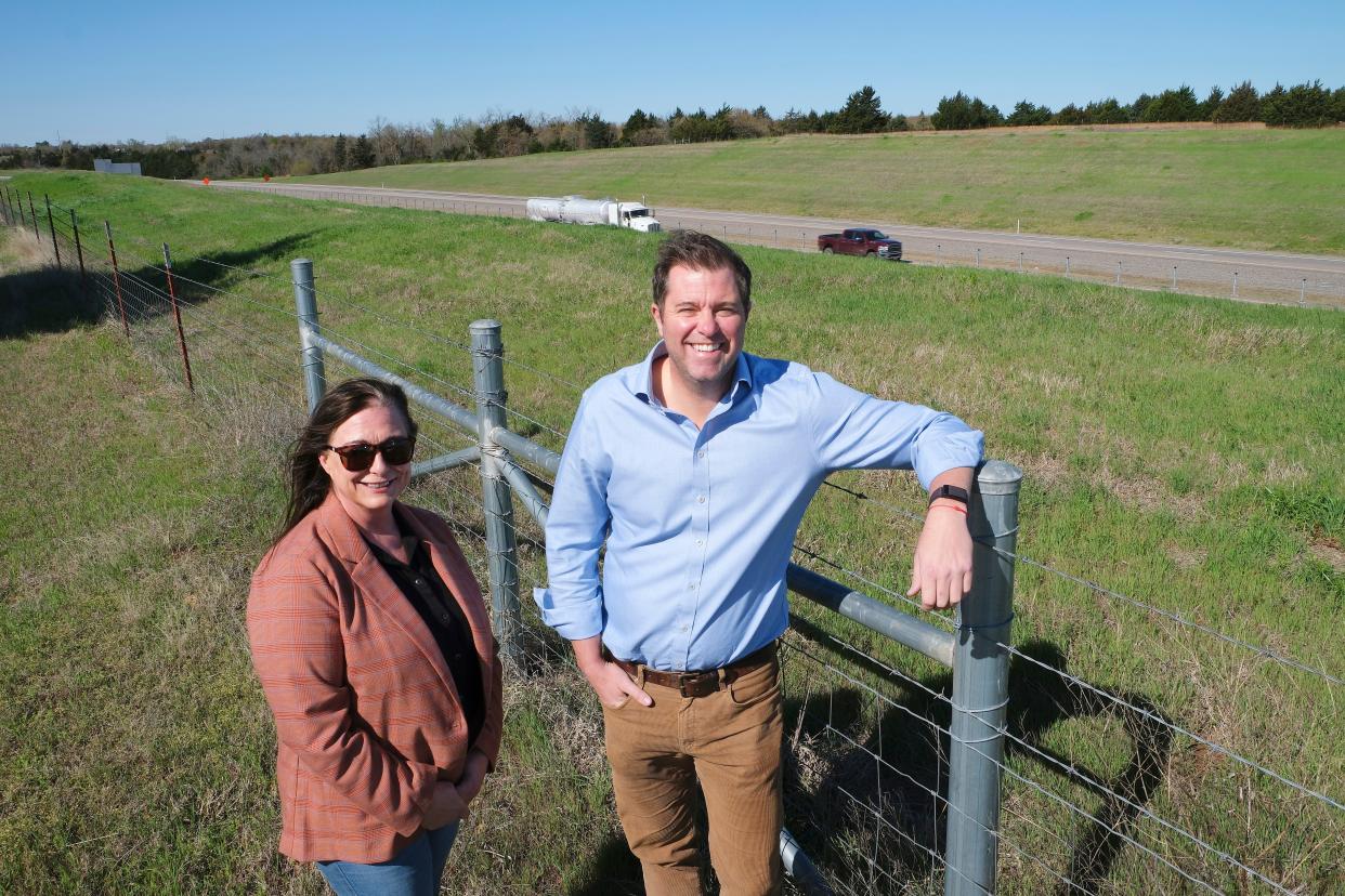 Samantha Brewer and attorney Nick Atwood stand near where Brewer's 3,600-square-foot home once sat before it was taken by eminent domain to make way for the Kickapoo Turnpike.