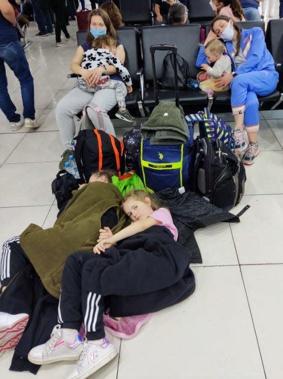 At left, Masha holding her sleeping son Artem, and, at right, Olya, and her baby Nikol, along with Tania’s girls sleeping on the floor of an airport, became the norm for the Ukrainian families on their week-long journey to the U.S.