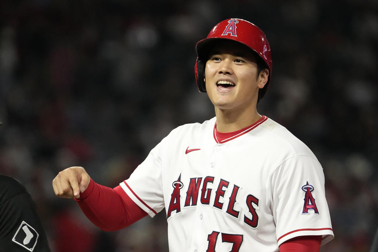 Los Angeles Angels' Shohei Ohtani talks to members of the Chicago White Sox as they sit in their dugout after hitting a single during the eighth inning of a baseball game Wednesday, June 28, 2023, in Anaheim, Calif. (AP Photo/Mark J. Terrill)