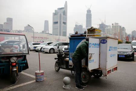 A man unloads parcels from a vehicle of the ZTO Express delivery service near the Central Business District in Beijing, China, October 27, 2016. REUTERS/Thomas Peter