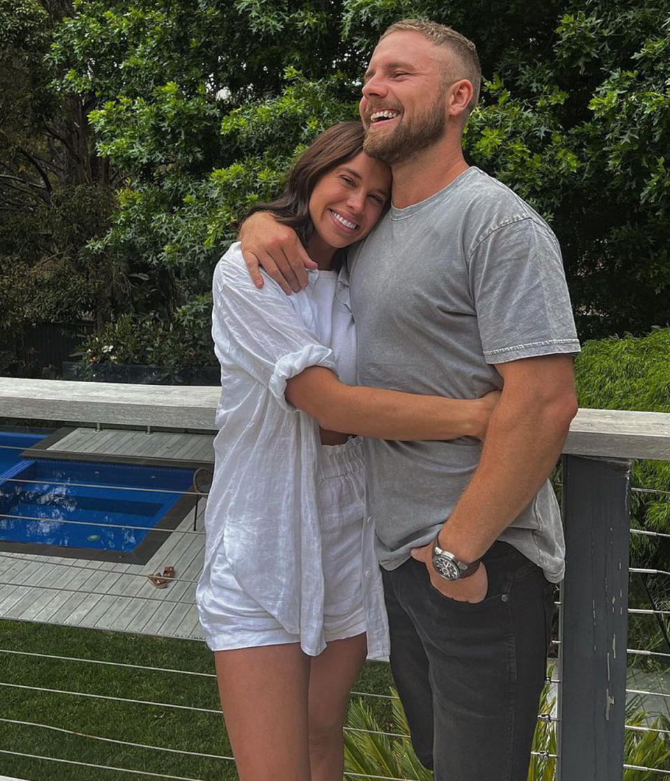 Bonnie Anderson is in a white shirt and shorts, pictured hugging Sam who is in a grey t shirt and jeans.