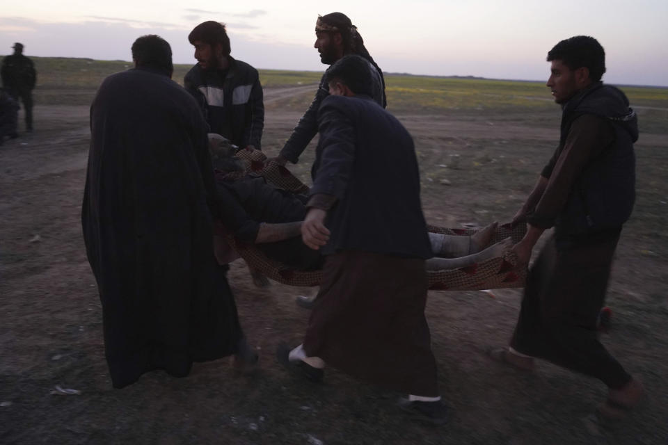 A wounded man is carried after being evacuated out of the last territory held by Islamic State militants, outside Baghouz, Syria, Monday, March 4, 2019. Hundreds of people including IS fighters evacuated their last foothold in eastern Syria hours after U.S.-backed Syrian fighters said they were forced to slow their advance because the extremists are using civilians as human shields.(AP Photo/Andrea Rosa)