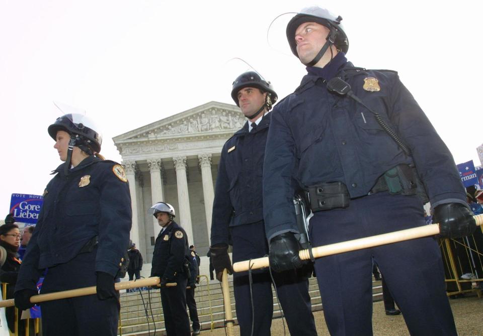 Police officers in riot gear outside the Supreme Court on Dec. 11, 2000, as the court took up a case that would decide the 2000 presidential election. <a href="https://www.gettyimages.com/detail/news-photo/police-officers-with-riot-gears-stand-guard-during-a-news-photo/1311448?adppopup=true" rel="nofollow noopener" target="_blank" data-ylk="slk:Hulton Archive/Getty Images;elm:context_link;itc:0;sec:content-canvas" class="link ">Hulton Archive/Getty Images</a>