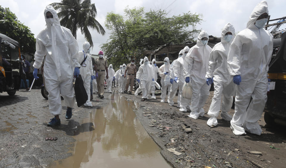 Health workers escorted by policemen arrive to screen people for COVID-19 symptoms at a slum in Mumbai, India, Friday, July 10, 2020. India has overtaken Russia to become the third worst-affected nation by the coronavirus pandemic. (AP Photo/Rafiq Maqbool)