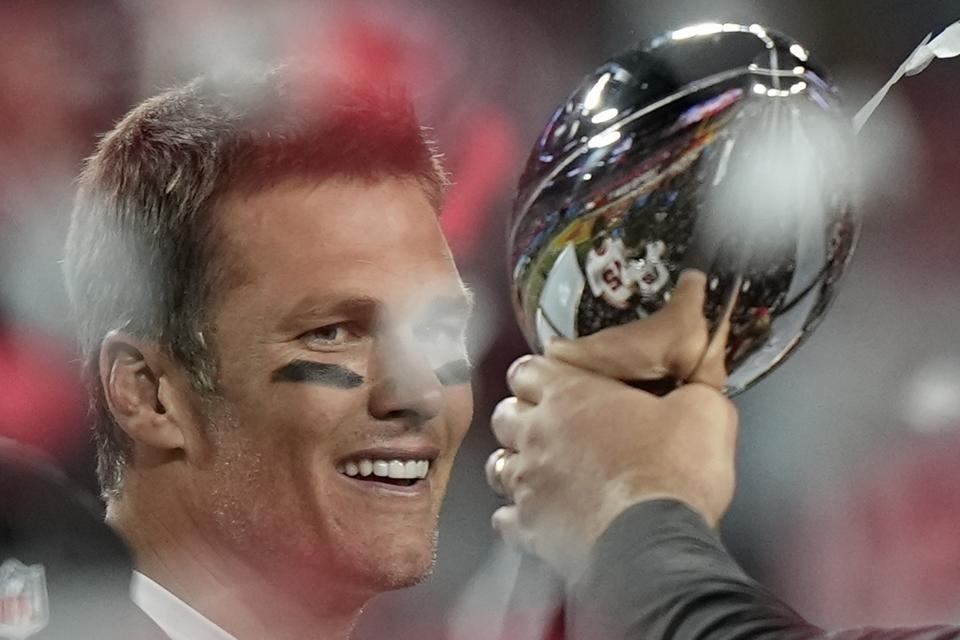 El quarterback Tom Brady de los Buccaneers de Tampa Bay observa el trofeo del Super Bowl al celebrar la victoria ante los Chiefs de Kansas City, el domingo 7 de febrero de 2021, en Tampa, Florida. (AP Foto/David J. Phillip)