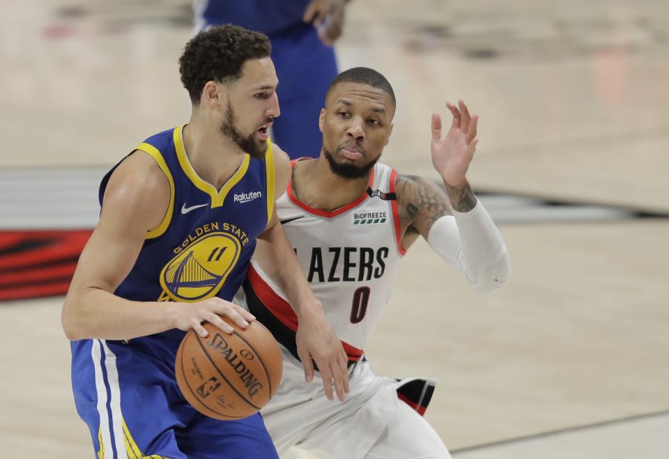 Golden State Warriors guard Klay Thompson (11) drives around Portland Trail Blazers guard Damian Lillard (0) during the second half of Game 3 of the NBA basketball playoffs Western Conference finals against the Portland Trail Blazers, Saturday, May 18, 2019, in Portland, Ore. The Warriors won 110-99. (AP Photo/Ted S. Warren)